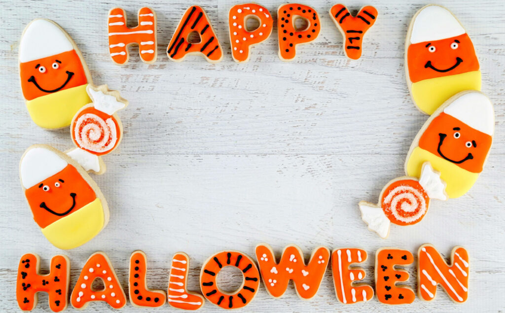 Spooky Sweetness: Adorable Halloween Greeting Cookies with Candies and Icing Wallpaper