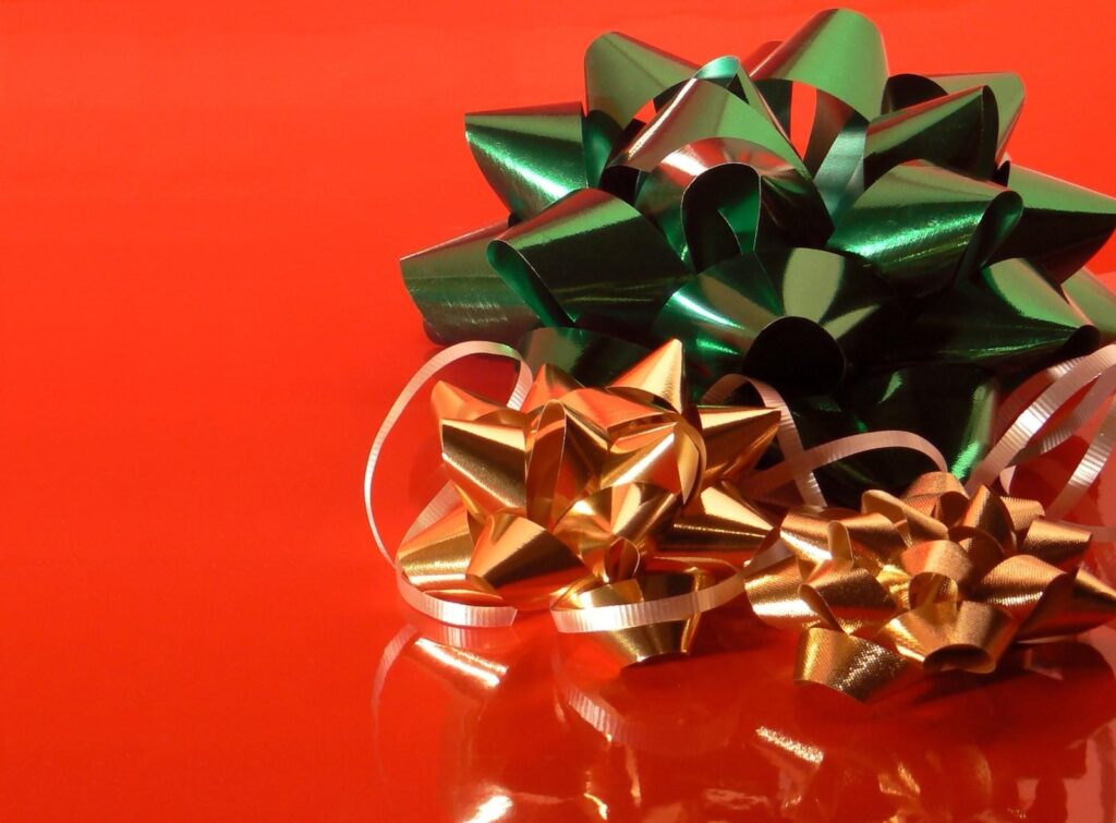 Festive Holiday Bows Wallpaper: Green & Gold on Glossy Red Background