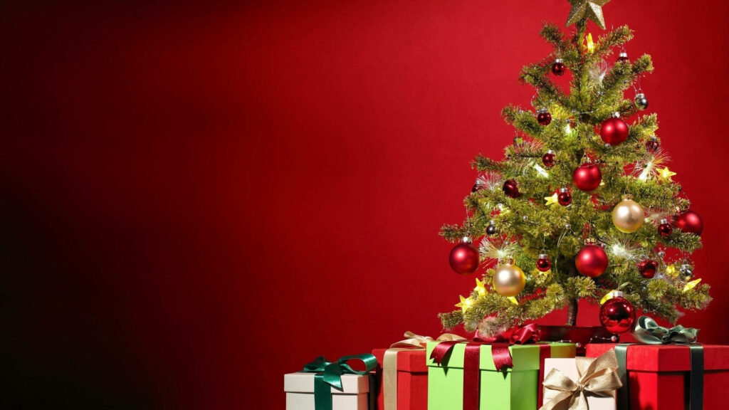 Festive Delight: Vibrant Christmas Wallpaper Showcasing a Stunning Red Hue, Adorned Tree, and Presents