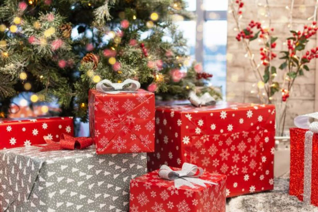 Festive Holiday Scene: Red & Grey Gifts Under Twinkling Christmas Tree Wallpaper
