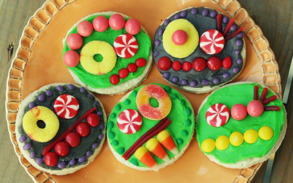 Vibrant Cookie Wallpaper: Festive Multi-Colored Treats on Orange Plate