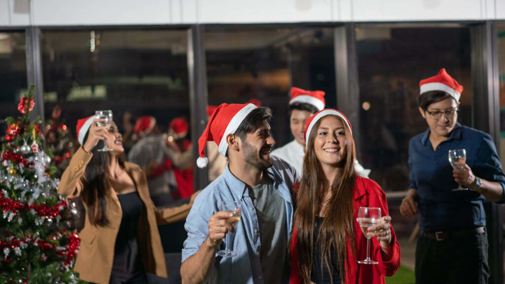Joyful Office Holiday Party: Colleagues Celebrate in Santa Hats Wallpaper