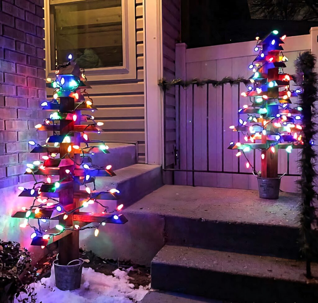 Festive Outdoor Scene: Wooden Christmas Trees with Colorful Lights Wallpaper