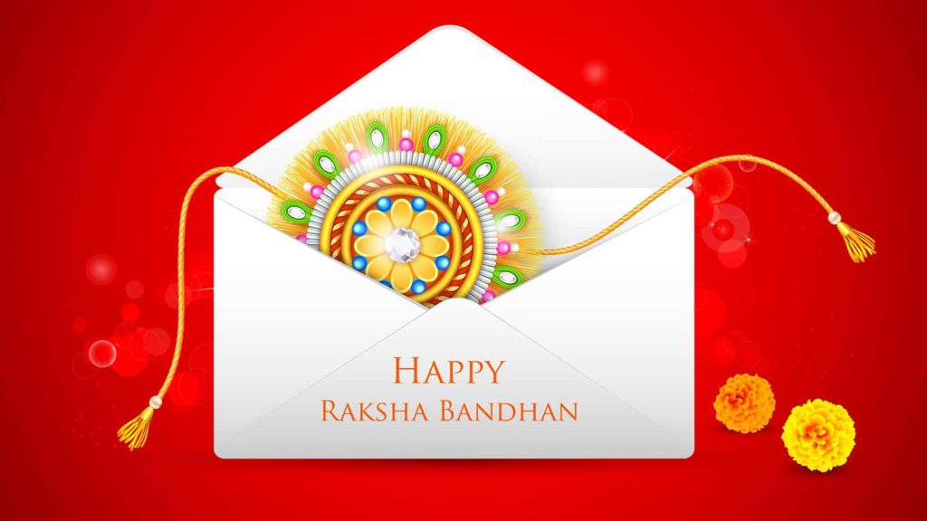 Ornate jeweled Rakhi in white envelope with yellow marigolds on vibrant red Raksha Bandhan wallpaper