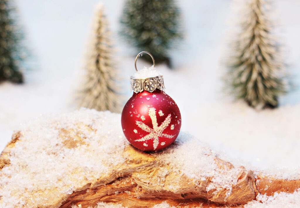 Festive Red Christmas Ornament on Snowy Wooden Surface Background Wallpaper