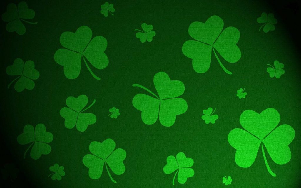 Festive Saint Patricks Day wallpaper with vibrant green shamrocks on dark textured background