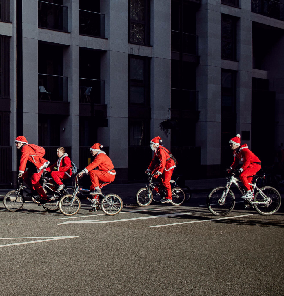 Santa Costumes on Bikes: Festive Urban Scene Holiday Fun Wallpaper