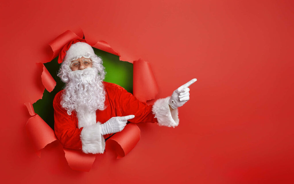 Festive Santa Claus Peeks Through Red Background, Spreading Cheer! Wallpaper