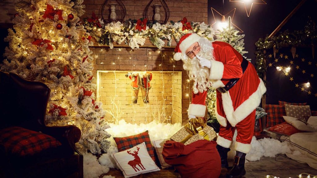 Festive Santa Claus Wallpaper: Cozy Christmas Fireplace Scene