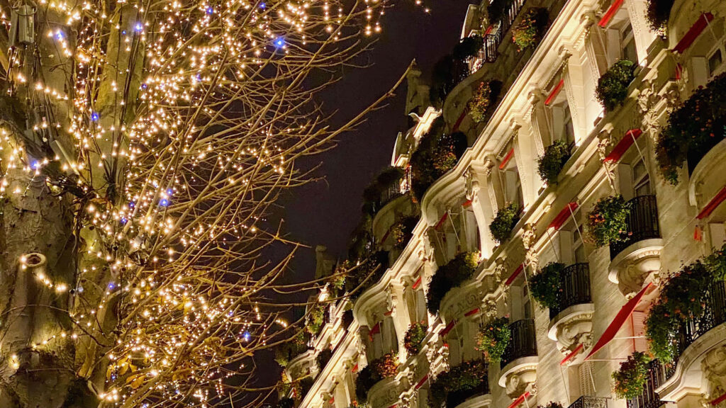 Festive Urban Street with Warm String Lights and Historic Architecture Wallpaper