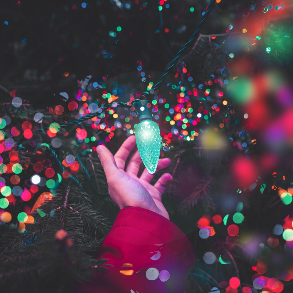 Magical Christmas Wallpaper: Hand Touching Glowing Holiday Lights