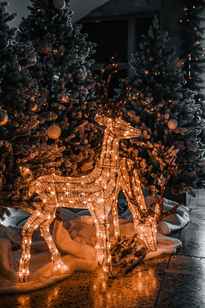 Cozy Holiday Wallpaper: Illuminated Deer & Festive Evergreen Trees