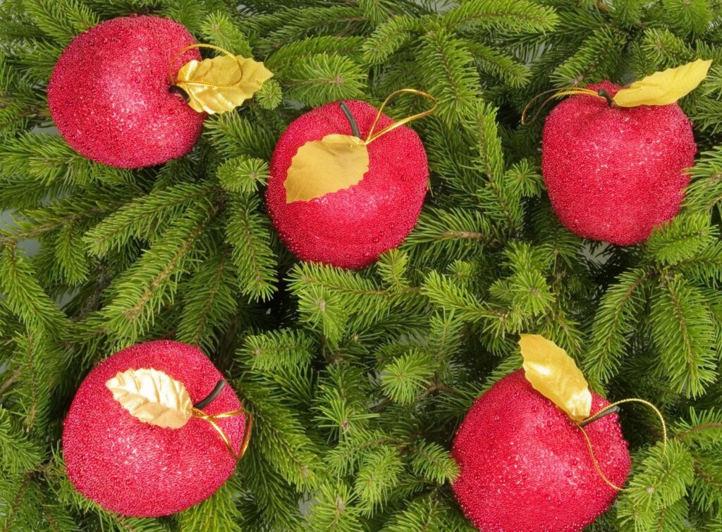 Festive Holiday Wallpaper: Lush Green Tree with Red Apple Decor