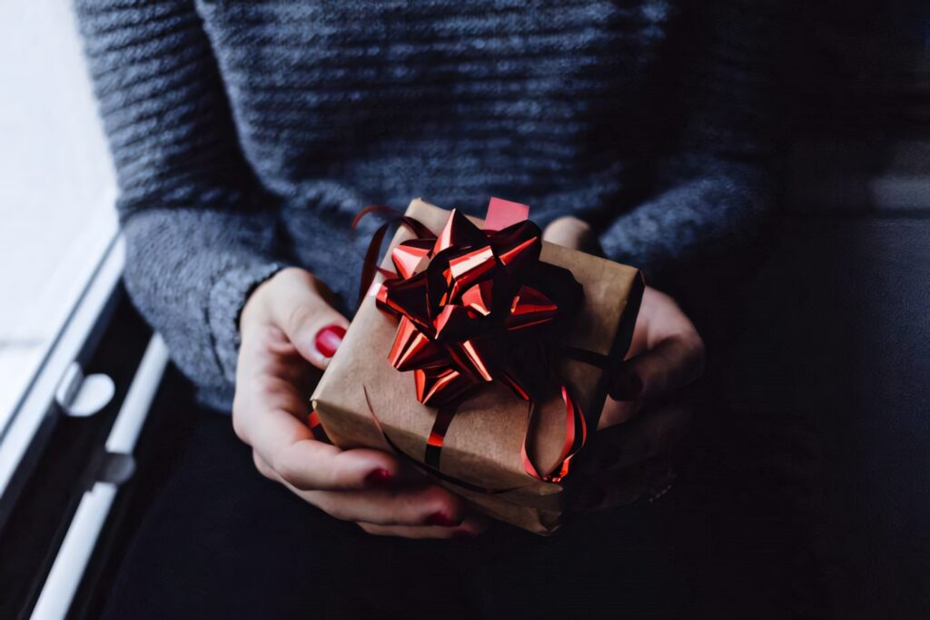 Festive Gift with Shiny Red Bow for a Perfect Holiday Season Wallpaper