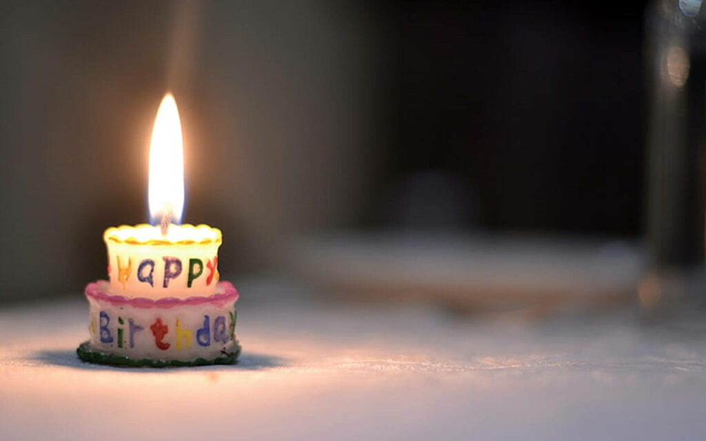 Festive Birthday Candle Glow on Mini Cake - Happy Birthday Bliss Wallpaper
