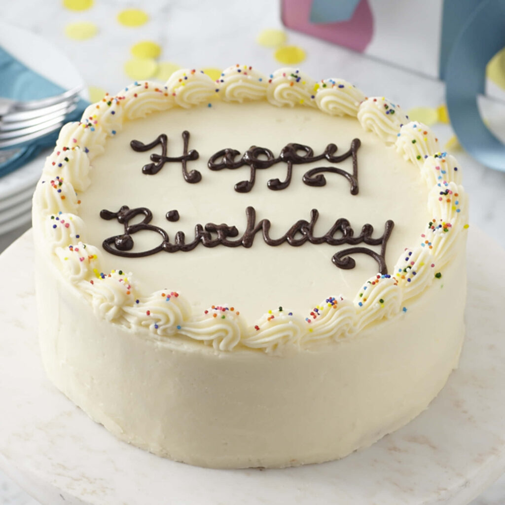 Festive White Frosted Birthday Cake with Chocolate Lettering & Sprinkles Wallpaper