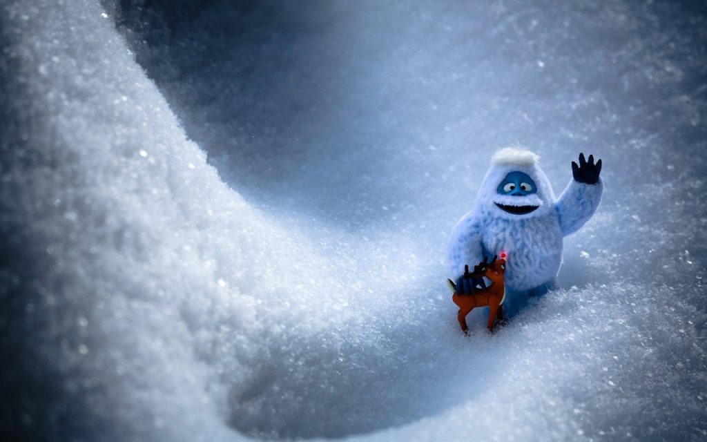 Festive wallpaper of Abominable Snow Monster and Rudolph in snowy winter toy photography scene