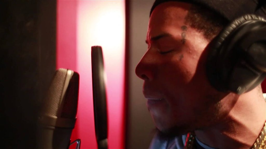 Fetty Wap recording in studio wearing headphones singing into microphone with red lighting Wallpaper