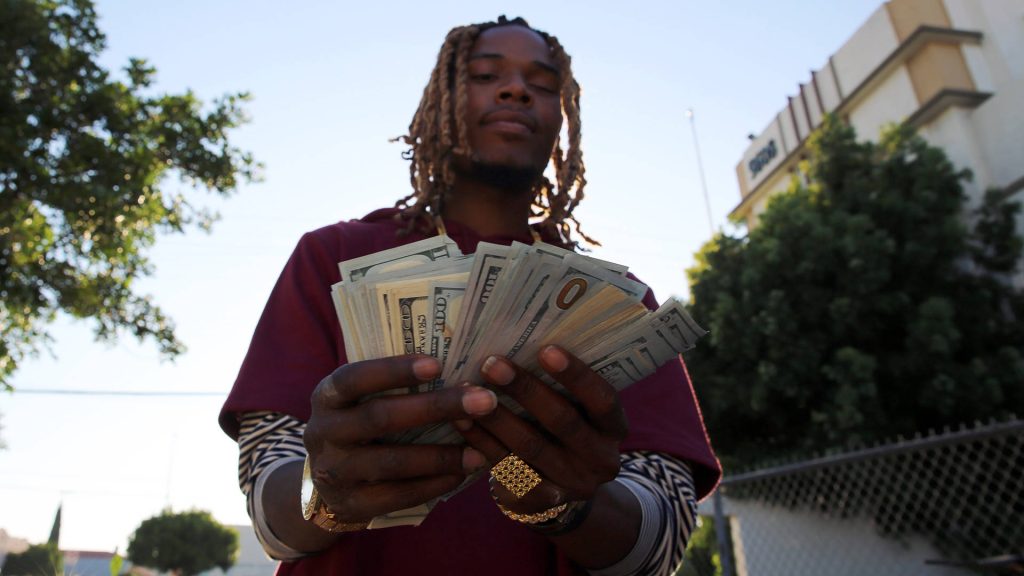 Rapper Fetty Wap flaunts cash and gold jewelry in urban daylight hip-hop style wallpaper background