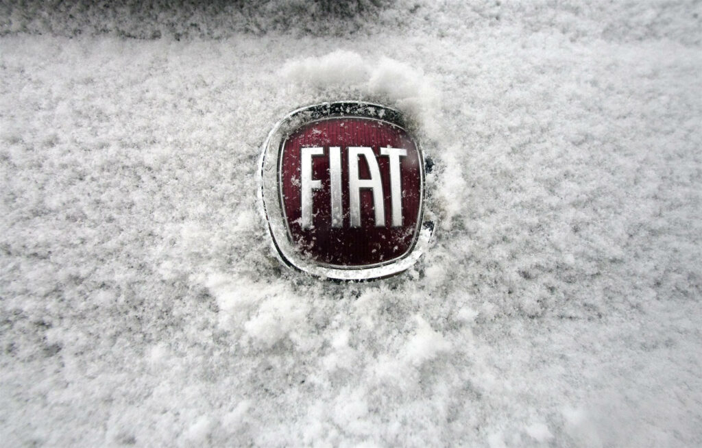 Fiat's Emblem in Winter Wonderland: A Frosty Tribute to Italian Automotive Excellence Wallpaper