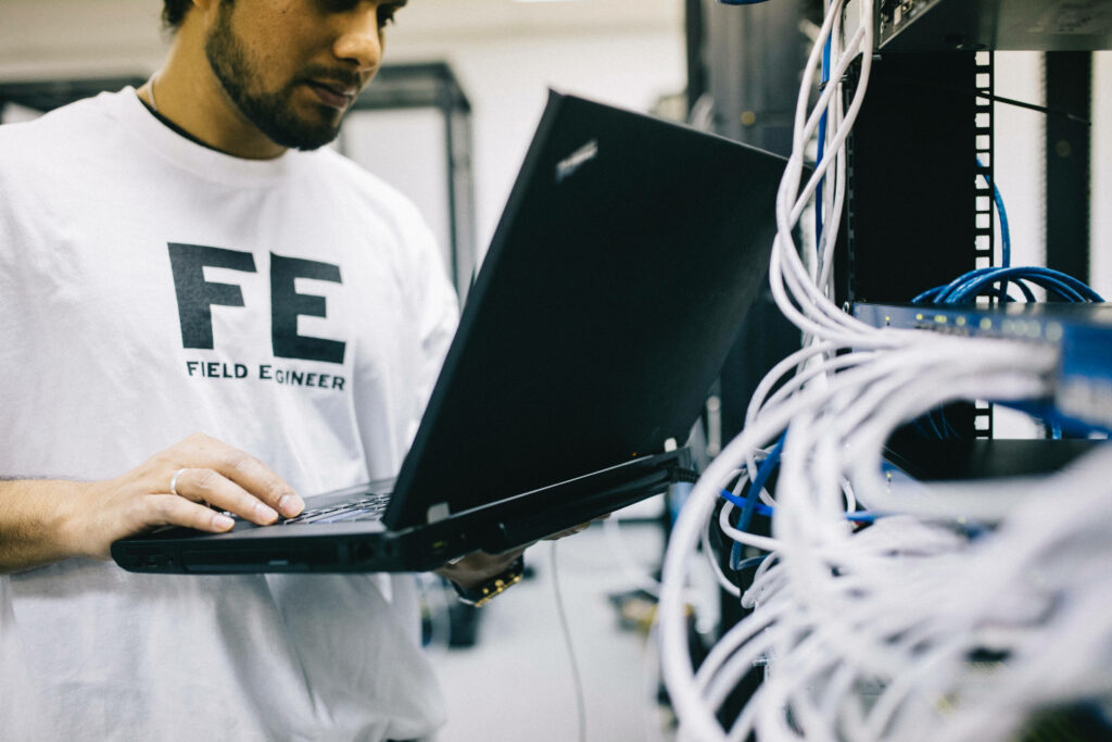 Field Engineer Testing Equipment with Laptop in Tech Setup Wallpaper