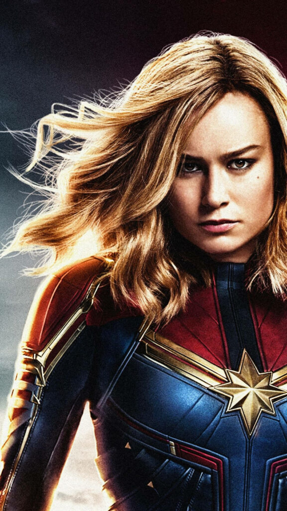 Flying with Power: Brie Larson as Captain Marvel Soars in Iconic Costume, Unlocking Her Inner Superhero! Wallpaper