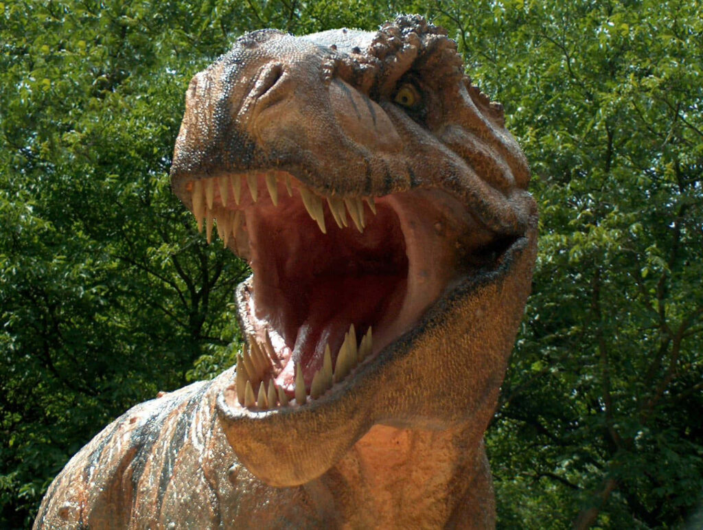 Majestic T-Rex Wallpaper: Fierce Dinosaur in Lush Wilderness