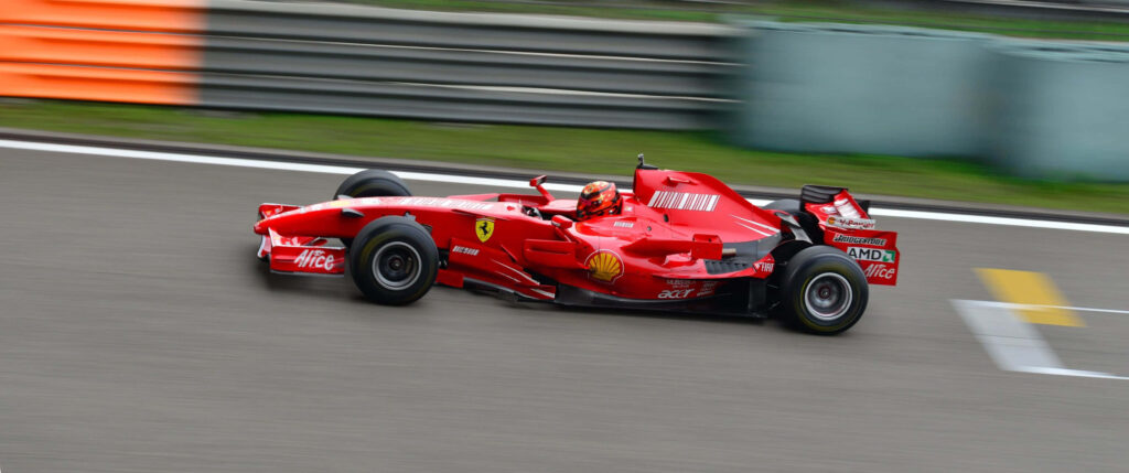 Speeding Scarlet: Blurry Track Bliss with a Red F1 Ferrari Wallpaper