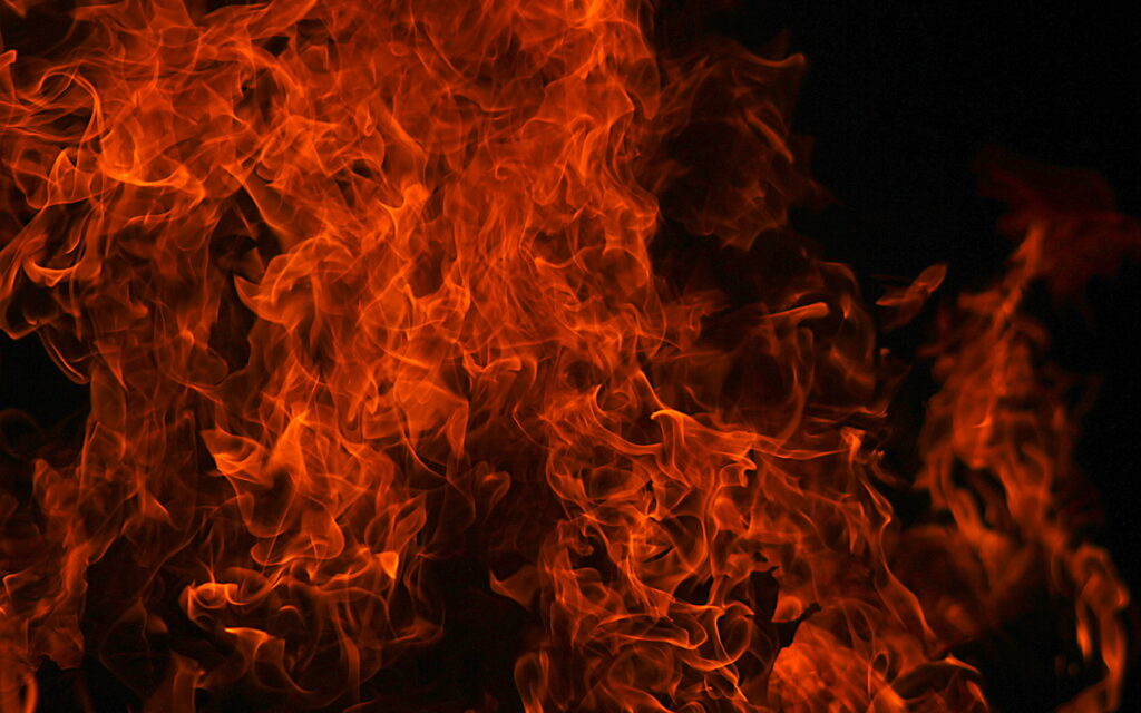 High-definition wallpaper of swirling orange and red flames on black background for fiery desktop