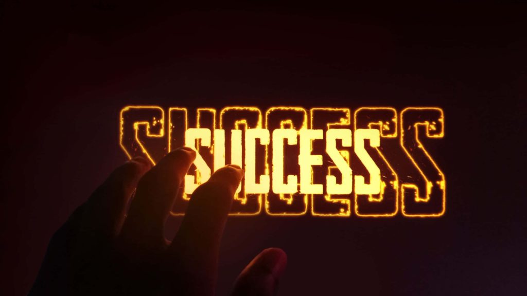 Motivational digital wallpaper with glowing fiery SUCCESS text and hand reaching for achievement
