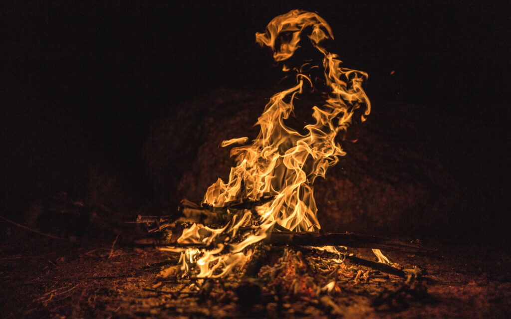 HD bonfire wallpaper with vibrant flames and glowing embers against a dark night background