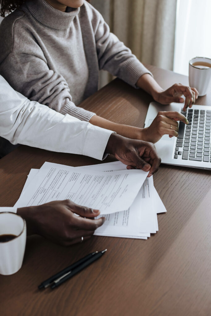 Couple Managing Finances: Intimate Capture of Hands on Wooden Desk Wallpaper
