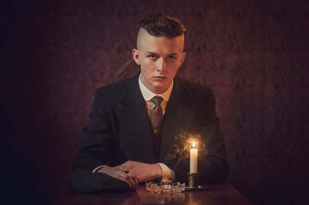 The Enigmatic Finn Shelby Bathed in Mysterious Candlelight: A Stunning 8k Peaky Blinders Wallpaper