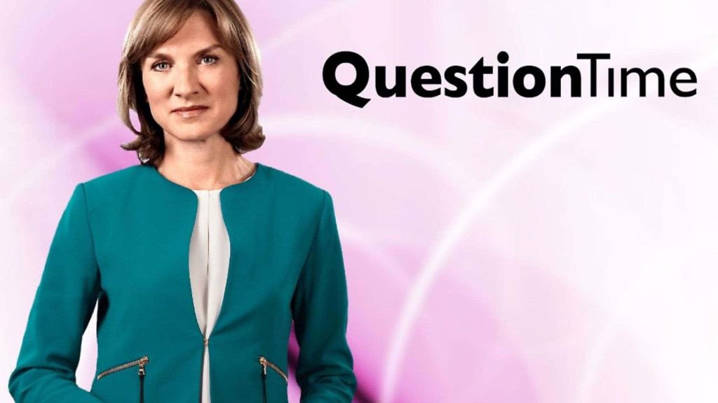 Fiona Bruce in teal jacket hosting BBC Question Time with pink studio background wallpaper