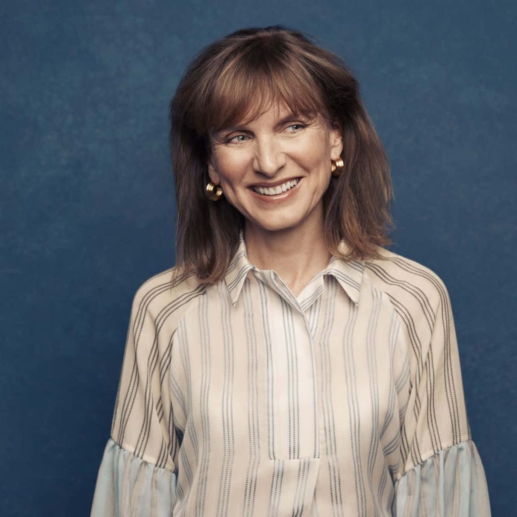 Portrait of journalist Fiona Bruce smiling in a cream striped blouse with gold hoop earrings Wallpaper