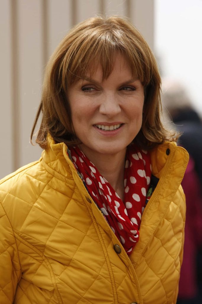 Fiona Bruce smiling portrait in yellow jacket and red polka dot scarf bright desktop wallpaper