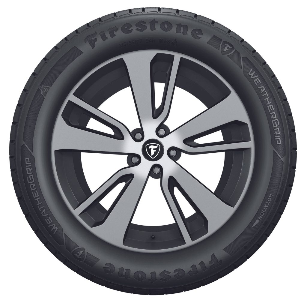 Firestone WeatherGrip tire on dark gray silver five-spoke alloy wheel studio shot white background Wallpaper