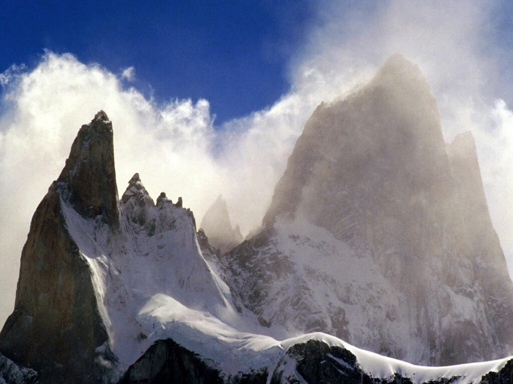 Dramatic Fitzroy Peak Andes snow-covered mountains blue sky swirling mist wild nature wallpaper