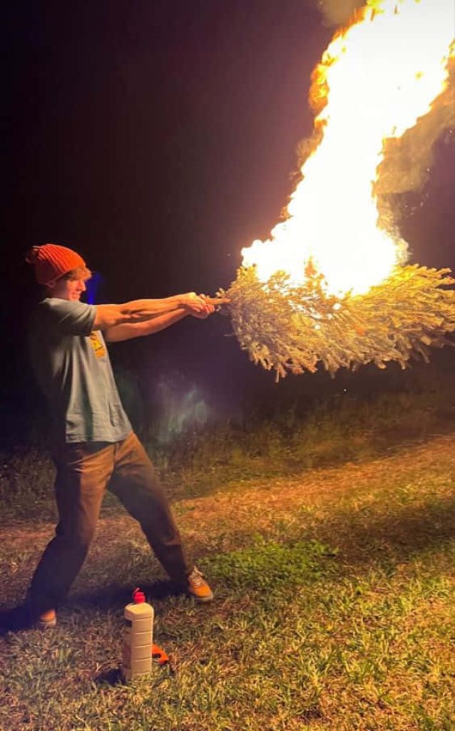 YouTuber Flamingo Albert Aretz holding flaming Christmas tree at night chaotic bold wallpaper
