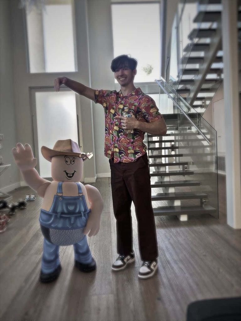 YouTuber Flamingo with life-sized Roblox farmer in modern home with glass staircase wallpaper