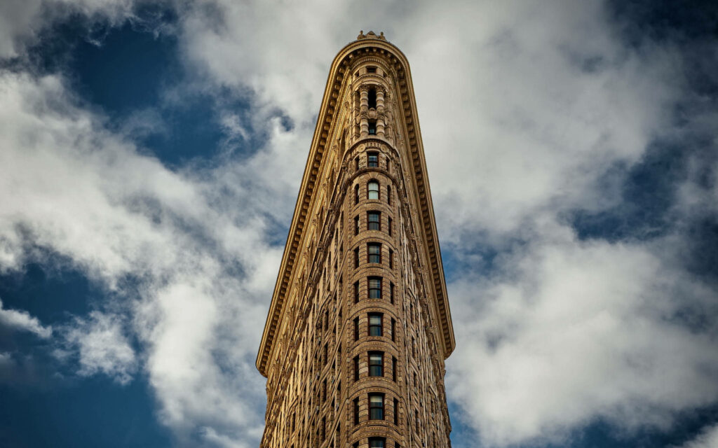 Flatiron Building in New York 4K wallpaper with dramatic sky and detailed warm architecture