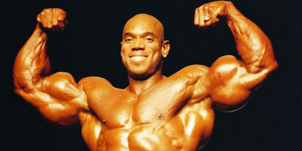 Flex Wheeler bodybuilding front double bicep pose with dramatic lighting on black background wallpaper