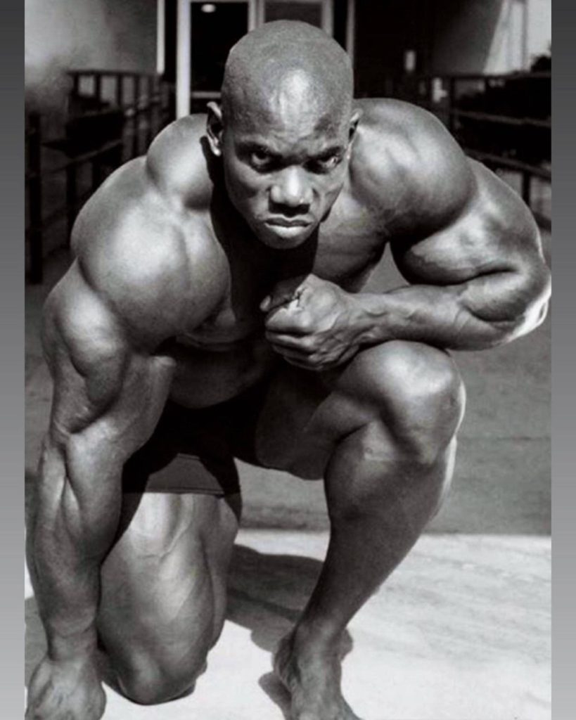 Flex Wheeler intense crouching pose black and white wallpaper showing muscular definition and strength