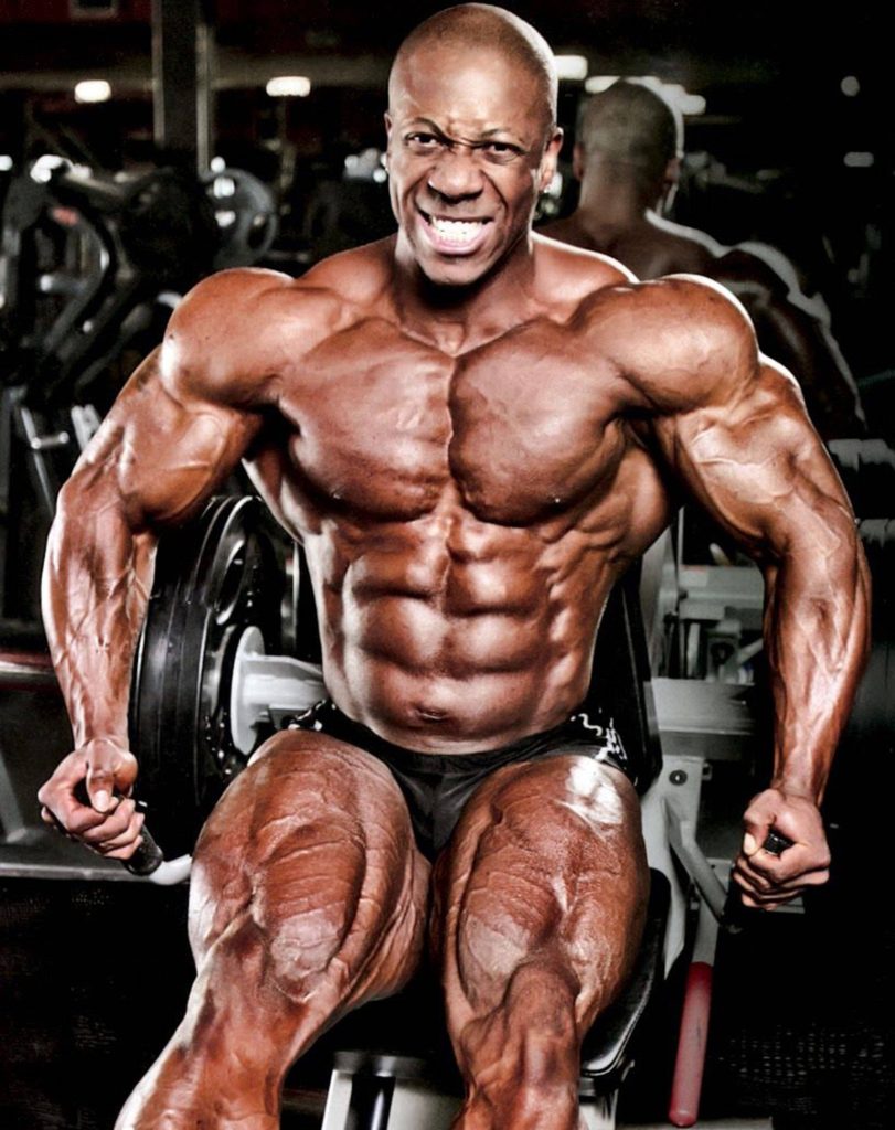 Flex Wheeler intense leg workout showing muscular quads and vascularity in moody gym background Wallpaper