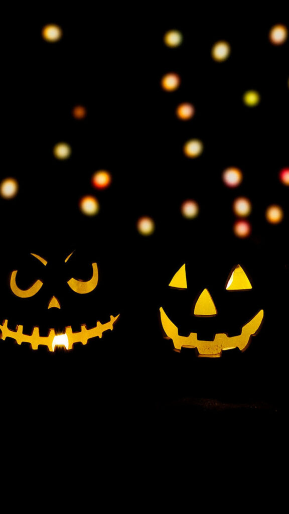 Enchanting Pumpkin Lanterns amidst Sparkling Halloween Bokeh Lights - Mesmerizing Phone Wallpaper