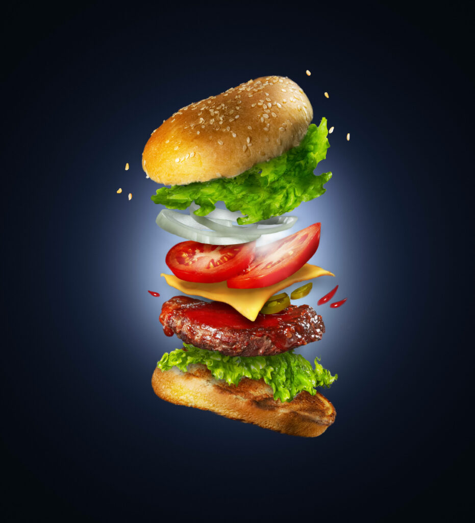 Floating Cheeseburger Wallpaper: Delicious Layers on Dark Background