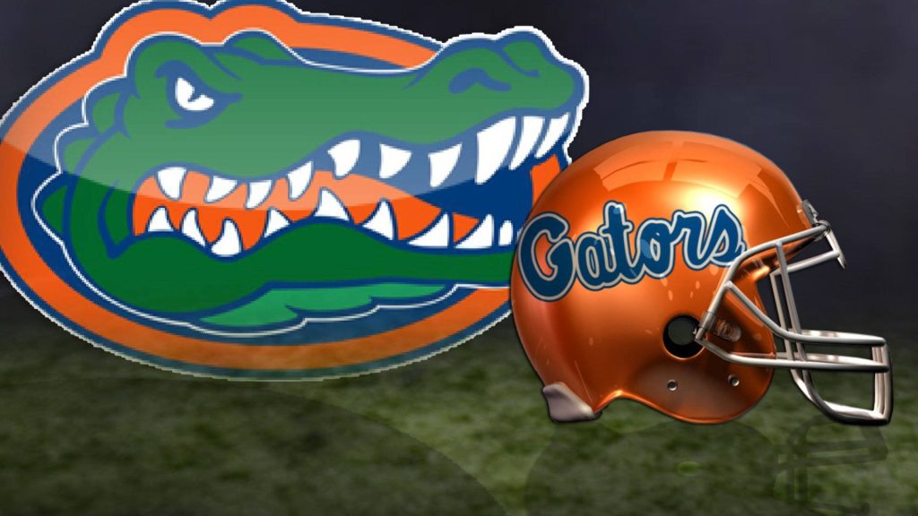 Florida Gators wallpaper with 3D orange helmet and alligator logo on blurred turf background