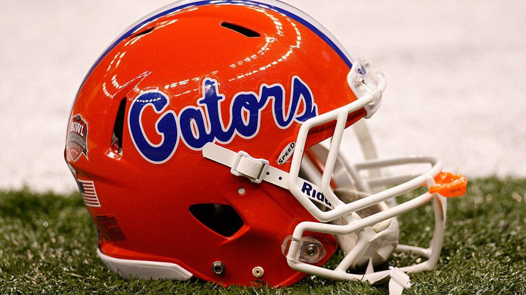 Florida Gators football helmet on green turf with blue logo white facemask and BCS sticker Wallpaper