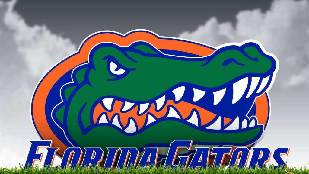 Florida Gators wallpaper with green alligator logo over grassy field and cloudy sky background