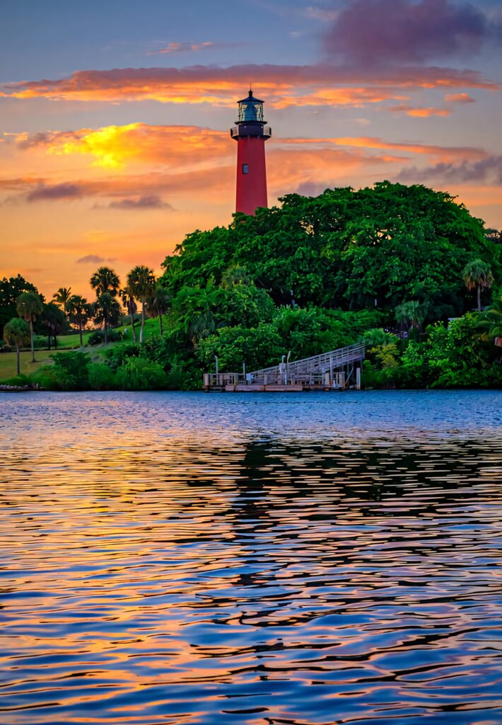 Florida sunset wallpaper with vibrant sky lush greenery classic lighthouse and calm reflective waters